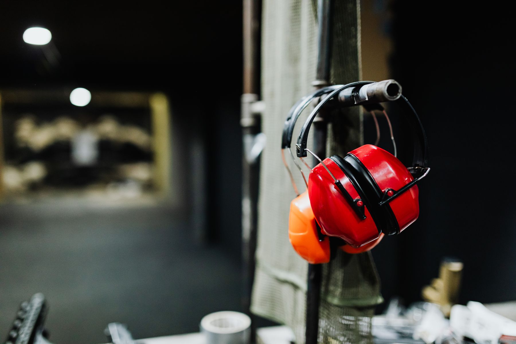 Red ear defenders hanging in a dimly lit room