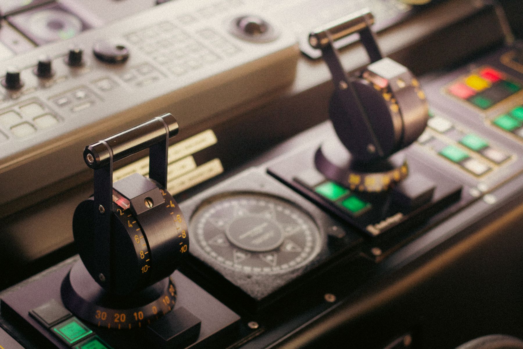 Engine control levers and a compass on a ship's bridge