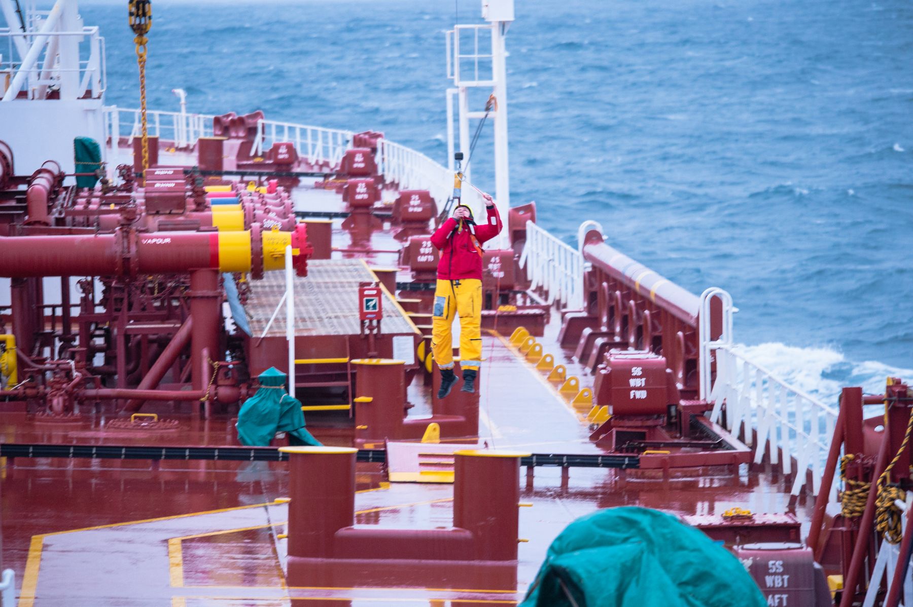 Crew working on the deck of a cargo ship at sea