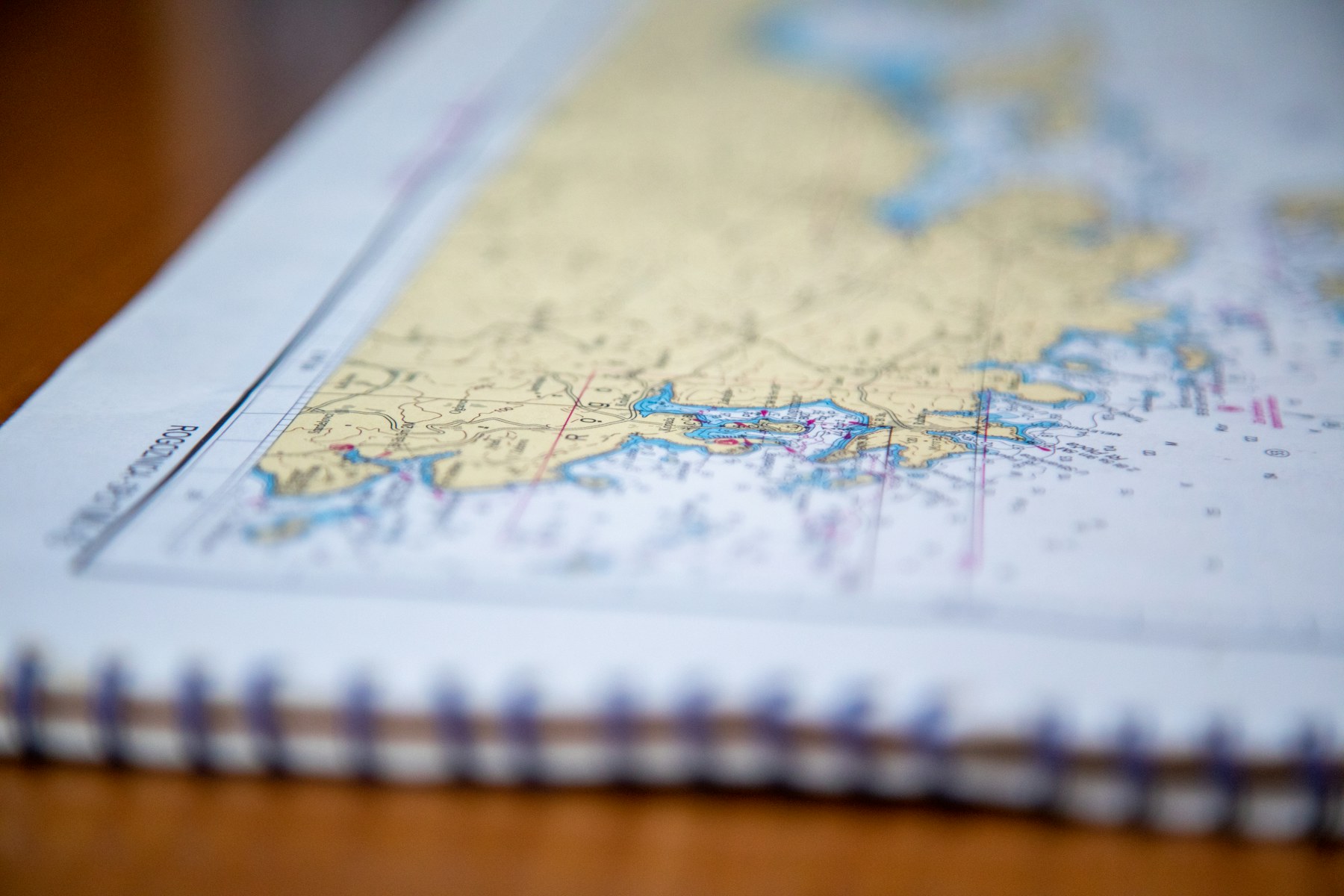 An open book of nautical charts on a table