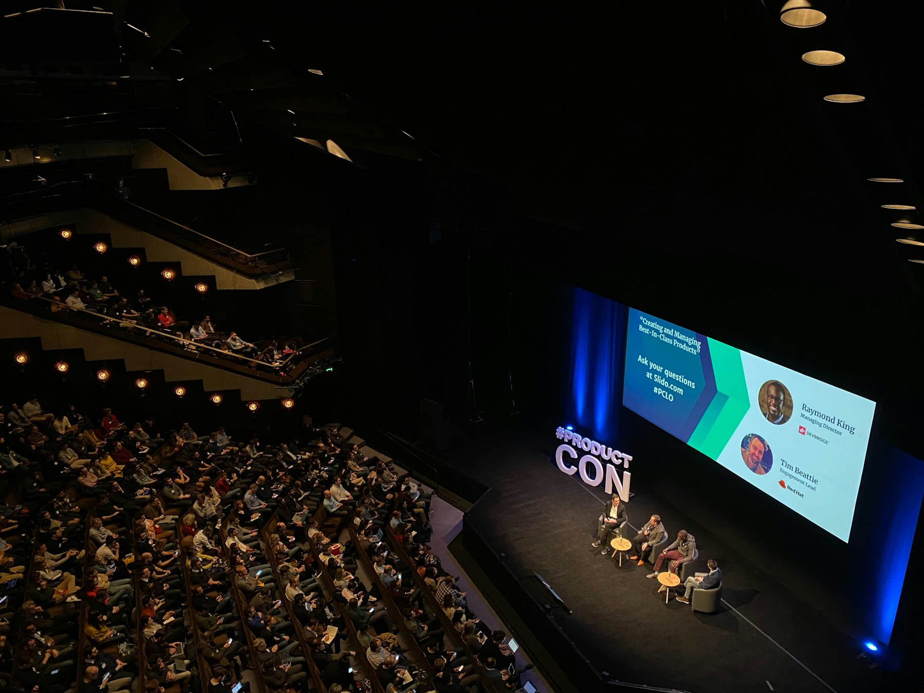 A panel discussion on stage in front of a large audience